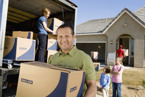Local movers handling furniture near a Bromley residential street